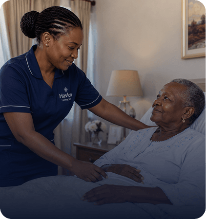 Nurse attending to an older woman resting in bed