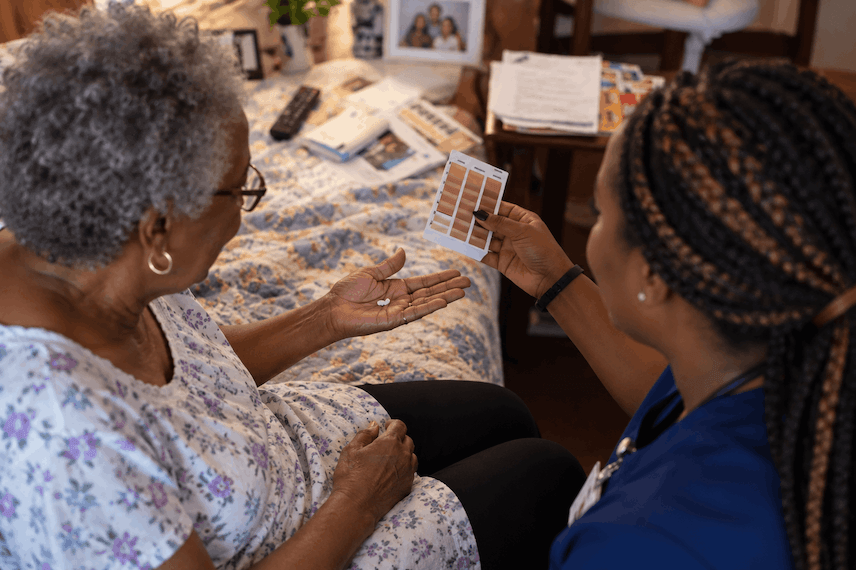 Nurse going through care notes with an older woman at home